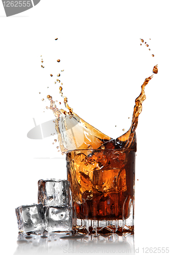 Image of splash of cola in glass with ice cubes isolated on white