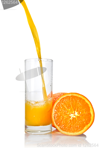 Image of orange juice poring into glass isolated on white