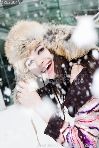 Image of smiling young woman in falling snow
