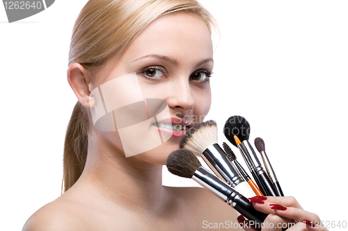 Image of Young smiling woman with make up brushes isolated on white