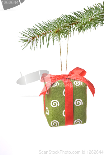 Image of Christmas gift on fir tree branch with snow isolated on white