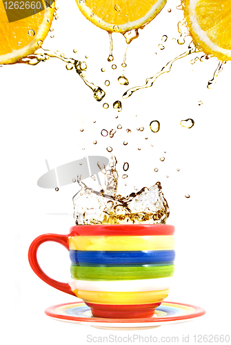 Image of three lemons, color cup and splash of tea isolated on white