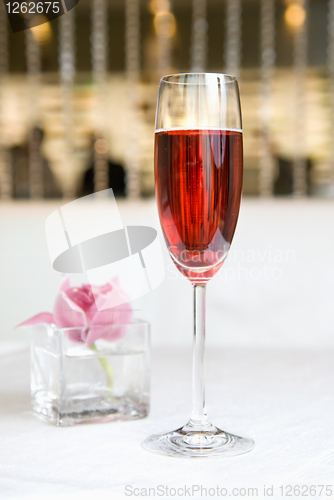 Image of red alcohol cocktail in glass with orchid