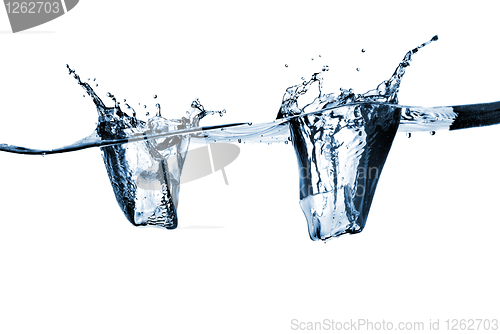 Image of ice cubes dropped into water with splash isolated on white