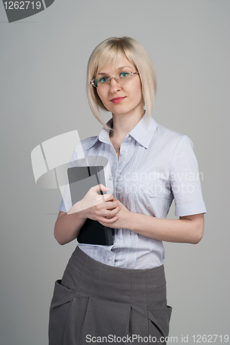 Image of Young attractive businesswoman holding diary isolated on grey