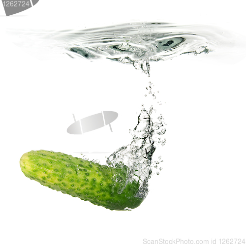 Image of green cucumber dropped into water isolated on white