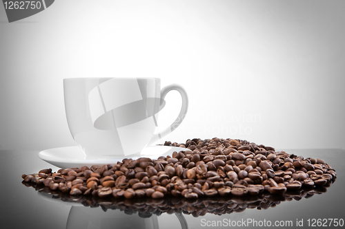 Image of white cup with coffee beans on white 