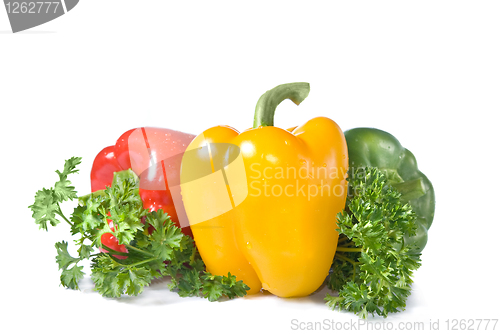Image of red, yellow and green pepper with parsley isolated on white
