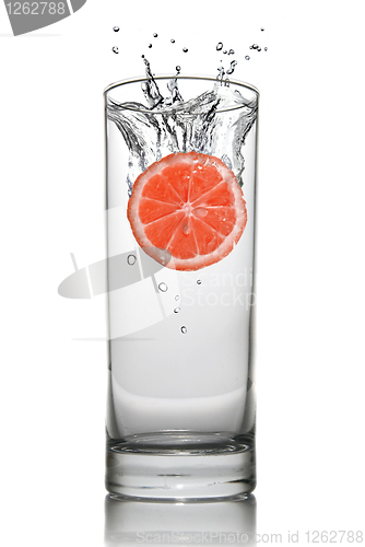 Image of Grapefruit dropped into water glass with splash isolated on whit