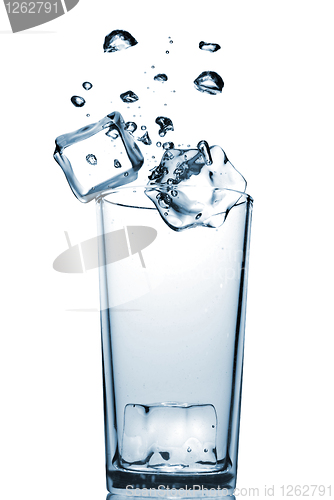 Image of ice cubes dropped into glass with bubbles isolated on white