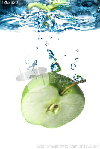 Image of green apple dropped into water with bubbles isolated on white