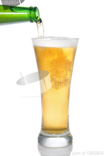 Image of Beer pouring from bottle into glass isolated on white