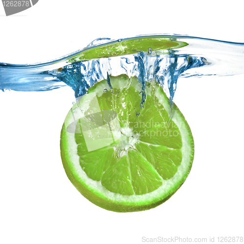 Image of Fresh lime dropped into water with splash isolated on white