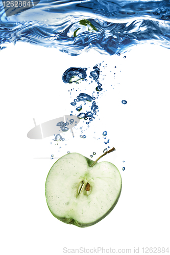 Image of green apple dropped into water with bubbles isolated on white