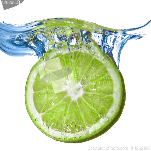 Image of Fresh lime dropped into water isolated on white