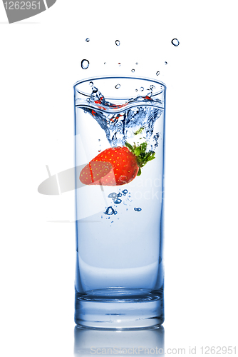 Image of Strawberry dropped into water glass with splash isolated on whit