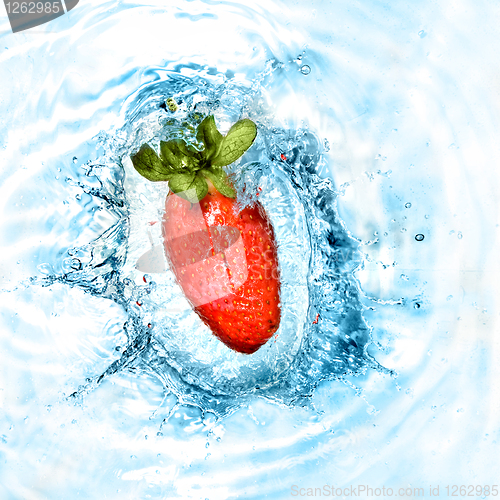 Image of Strawberry dropped into blue water with splash. Top view