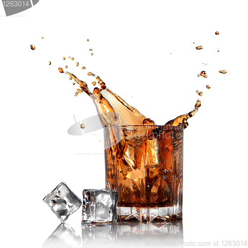 Image of splash of cola in glass with ice cubes isolated on white