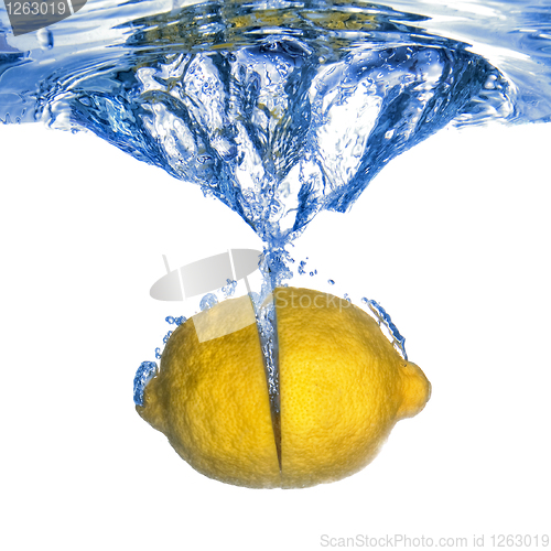 Image of Fresh lemon dropped into water with bubbles isolated on white