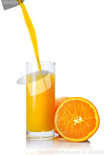 Image of orange juice poring into glass isolated on white