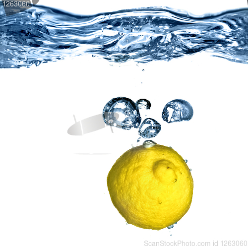 Image of Fresh lemon dropped into water with bubbles isolated on white