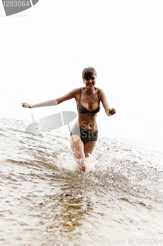 Image of happy girl run in the water