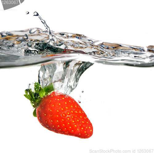 Image of Fresh strawberry dropped into water with splash isolated on whit