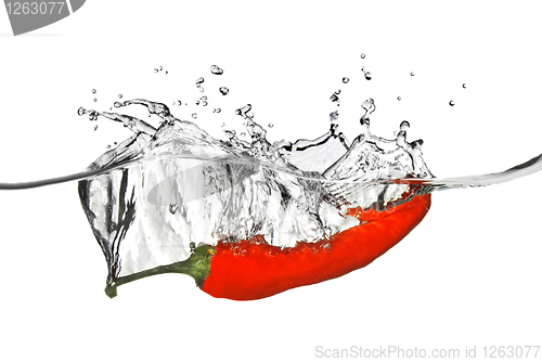 Image of red pepper dropped into water with splash isolated on white