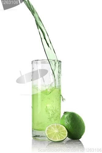 Image of green juice with lime pouring into glass isolated on white