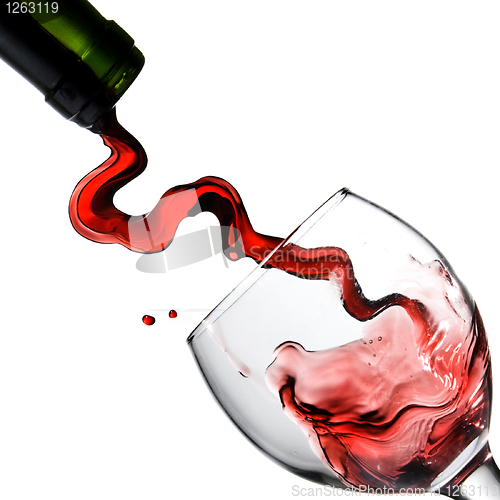Image of Pouring red wine in glass goblet isolated on white