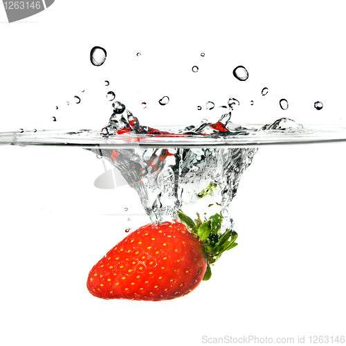 Image of Fresh strawberry dropped into water with splash isolated on whit