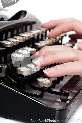 Image of fingers on vintage typing machine on white