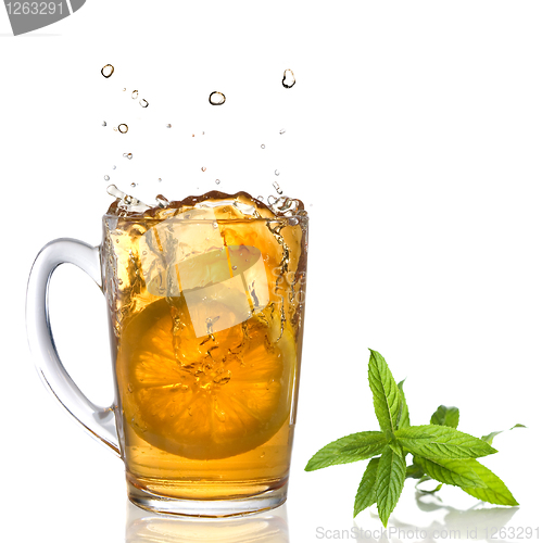 Image of lemon dropped into tea cup with splash and mint isolated on whit