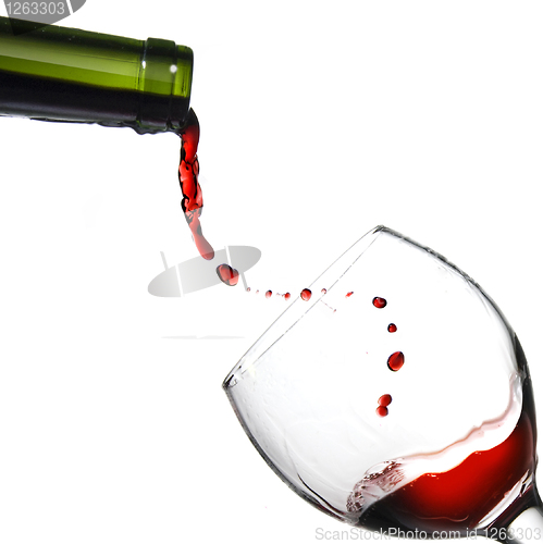 Image of Pouring red wine in glass goblet isolated on white