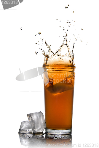 Image of Beautiful splash of cola in glass and ice cubes isolated on whit