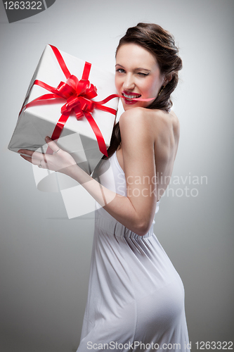 Image of Young smiling woman holding gift