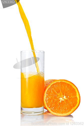 Image of orange juice poring into glass isolated on white