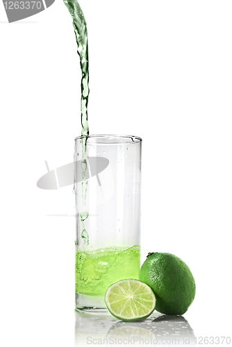 Image of green juice with lime pouring into glass isolated on white