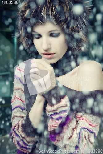 Image of young woman freeze under falling snow