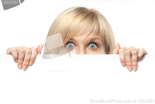 Image of surprised young woman holding white empty paper isolated on whit