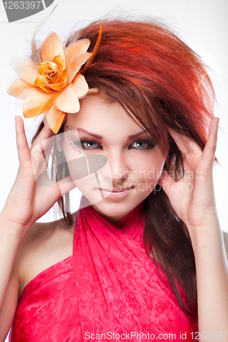 Image of Portrait of beautiful woman with flower in hair on white