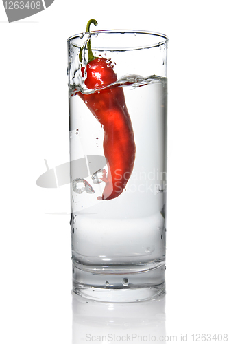 Image of red pepper dropped into water glass with bubbles