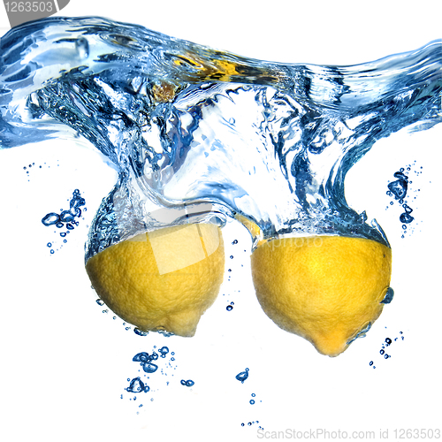 Image of Fresh lemon dropped into water with bubbles isolated on white