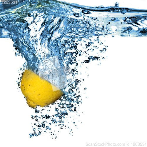 Image of Fresh lemon dropped into water with bubbles isolated on white