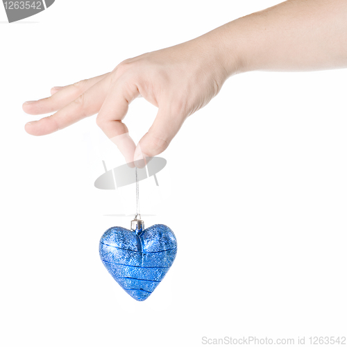 Image of arm holding blue christmas ball in shape of heart isolated on wh