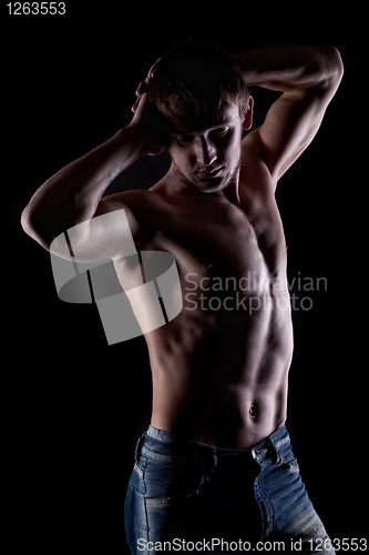 Image of Posing muscular naked man on black