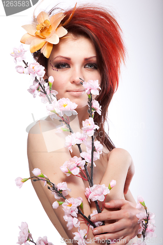 Image of Portrait of beautiful naked woman with spring flower in hair on white