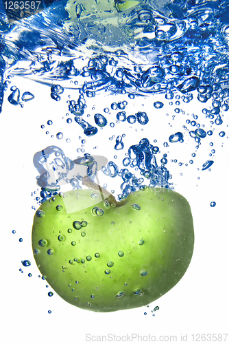 Image of green apple dropped into water with bubbles isolated on white