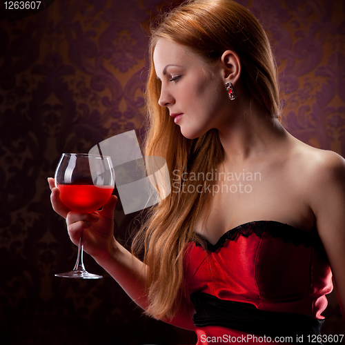 Image of elegant woman with red hair holding wine glass
