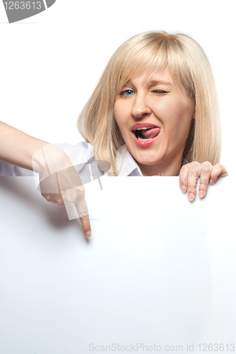 Image of Attractive funny woman holding white empty paper and pointing on